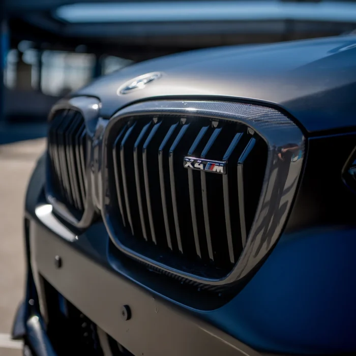 X4M Front Kidney Grille In Gloss Carbon With M Badge Detail, Emphasizing High-Performance Styling