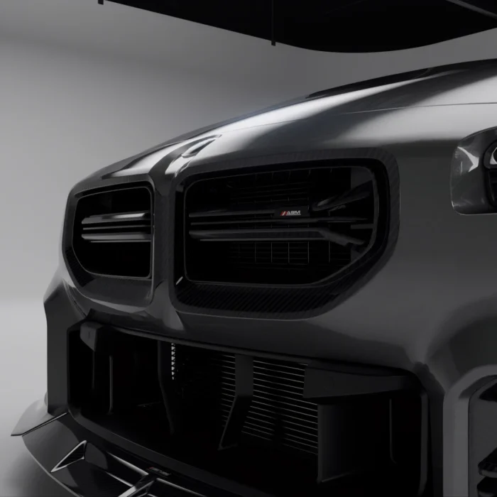 Close-up of carbon fibre front bumper grille on BMW G87 M2, showing dual intake and ASM badging