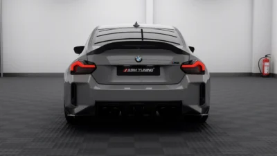 Rear straight-on shot of BMW G87 M2 in Nardo grey, highlighting dry carbon fibre trunk lip spoiler and quad-exit carbon diffuser