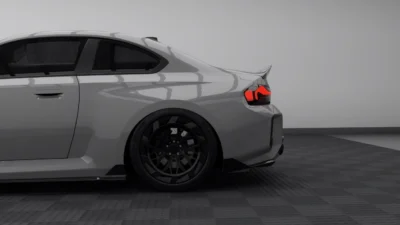 Side rear quarter view of BMW G87 M2 showcasing carbon fibre rear spoiler, diffuser, and custom forged wheels in stealth finish