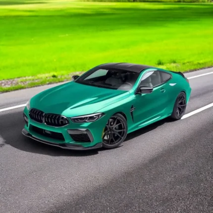 BMW M8 F91/F92/F93 with full gloss carbon fibre body kit – front angle driving view with splitter, skirts and grille
