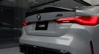 Close-up of left tail light and M4 badge on grey BMW G82 with pre-preg carbon fibre spoiler fitted by ASM