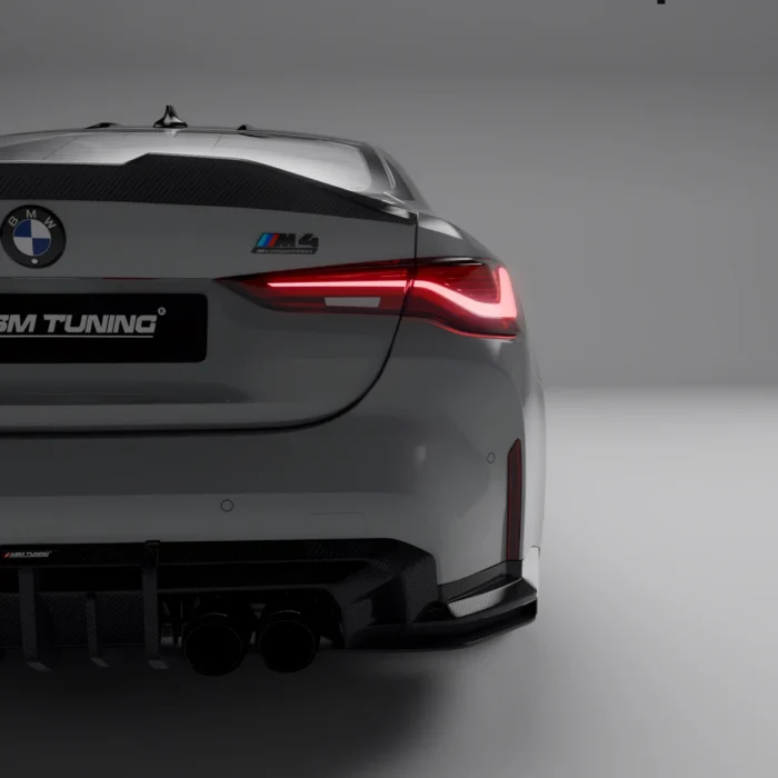 Side rear focus on M4 badge and carbon spoiler installed on grey BMW M4 G82 for enhanced trunk styling