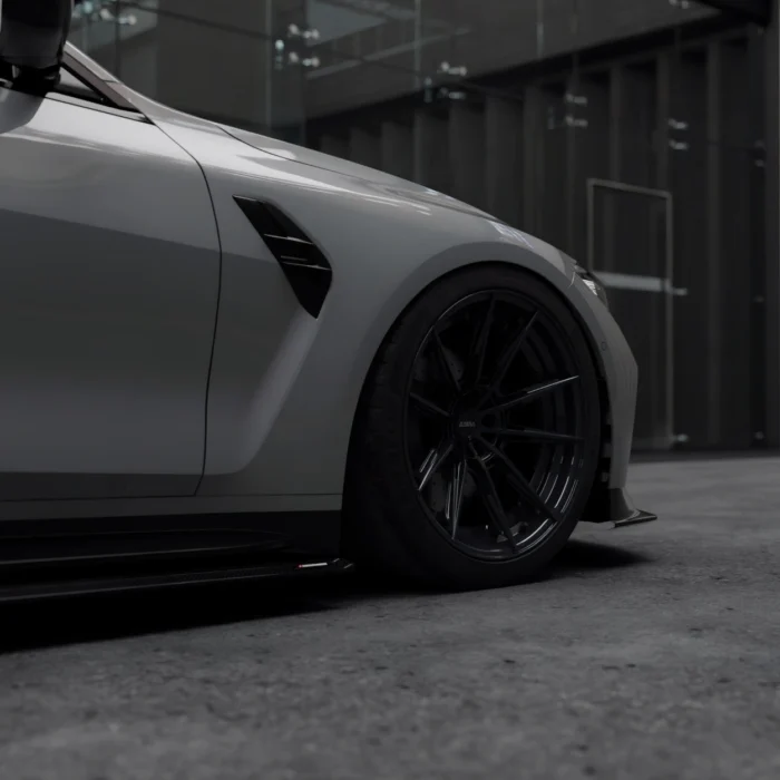 Low angle focus on front wheel and ASM carbon side skirt of grey BMW M4 G82