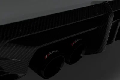 Close-up of BMW M4 G82/G83 rear diffuser showing dual carbon exhaust outlets and aggressive