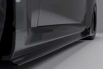 Close-up view of carbon fiber side skirt extensions installed on BMW G87 M2, enhancing side airflow and lowering visual stance