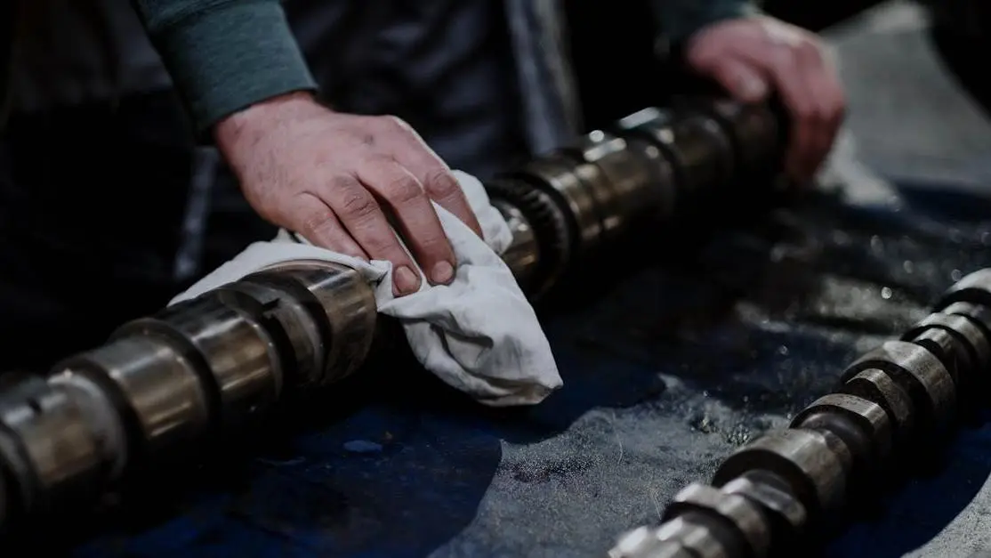 Mechanic cleaning camshaft, learn how to install a muffler delete.