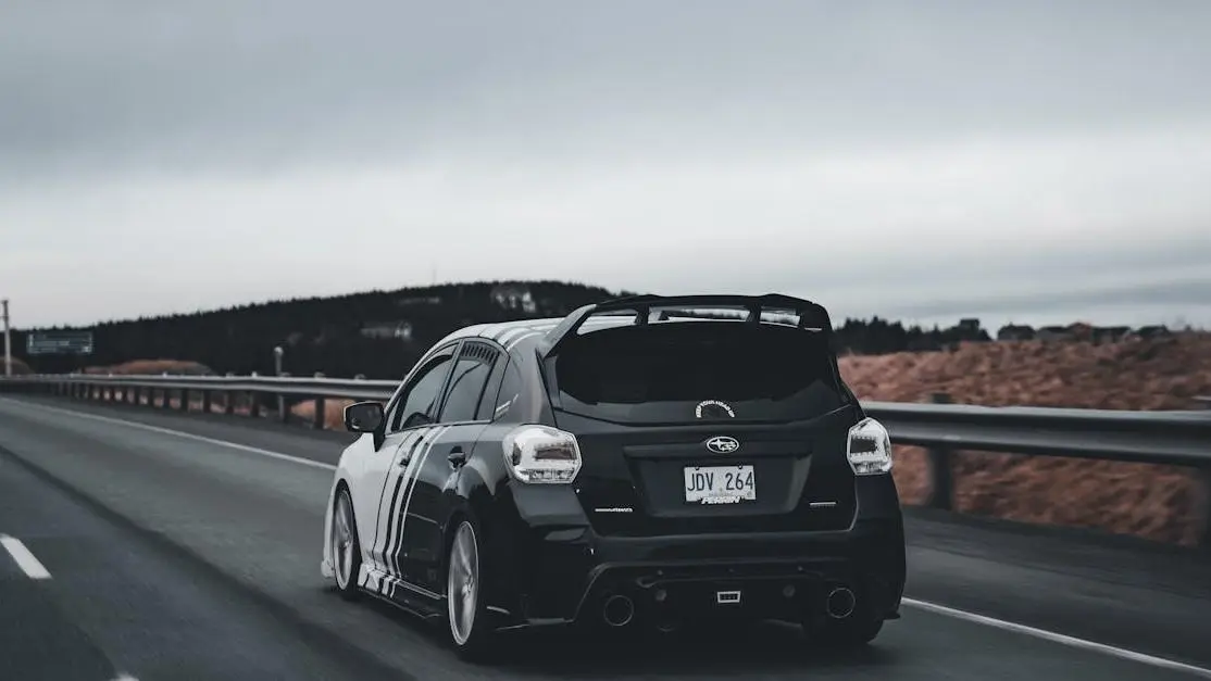 Subaru Impreza on highway showcasing performance exhaust system benefits for speed and efficiency