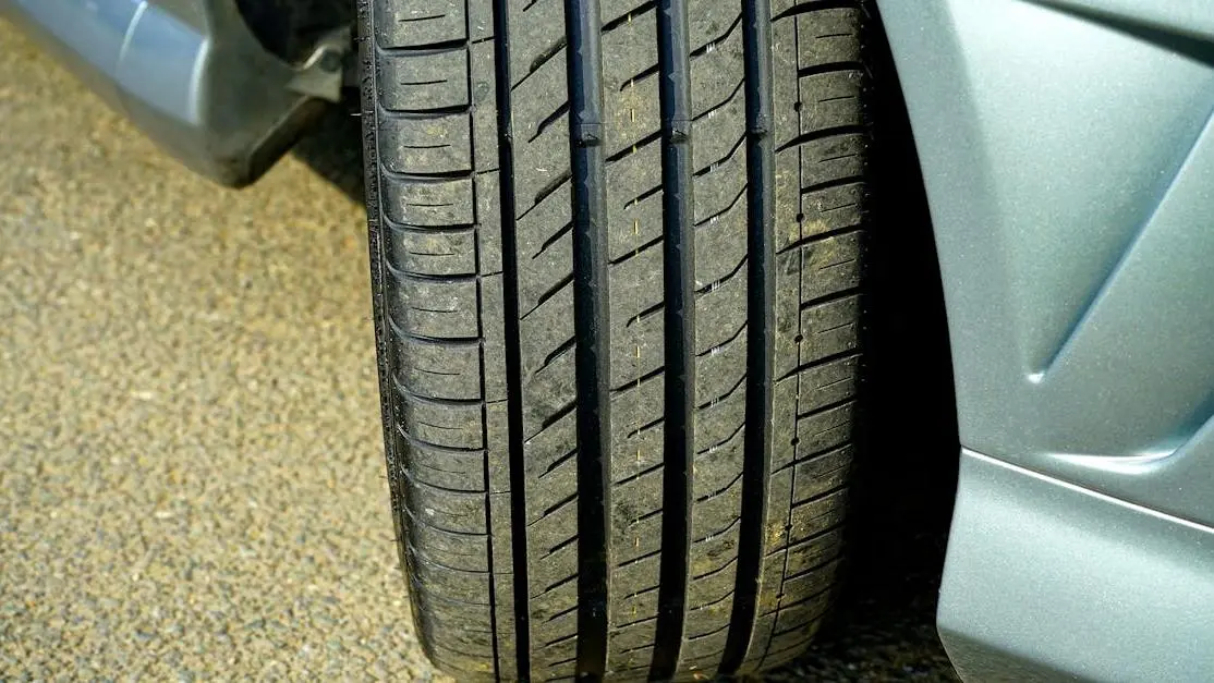 Car tire on asphalt showing tread detail, illustrating best tire pressure for grip.