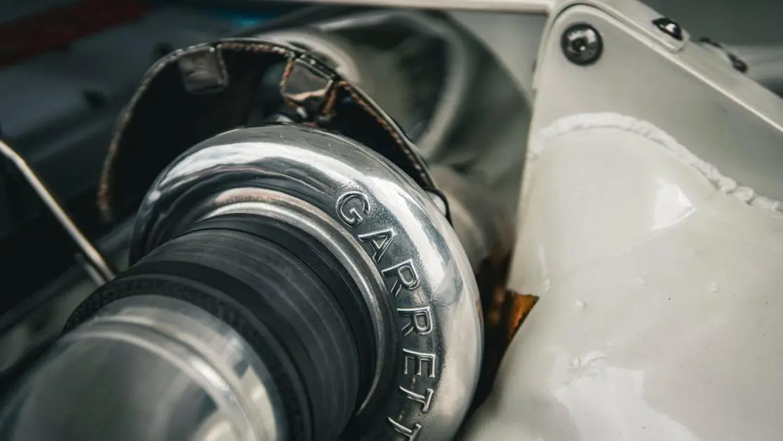 Turbo flutter vs blow off valve comparison with close-up of a Garrett turbocharger in a car engine