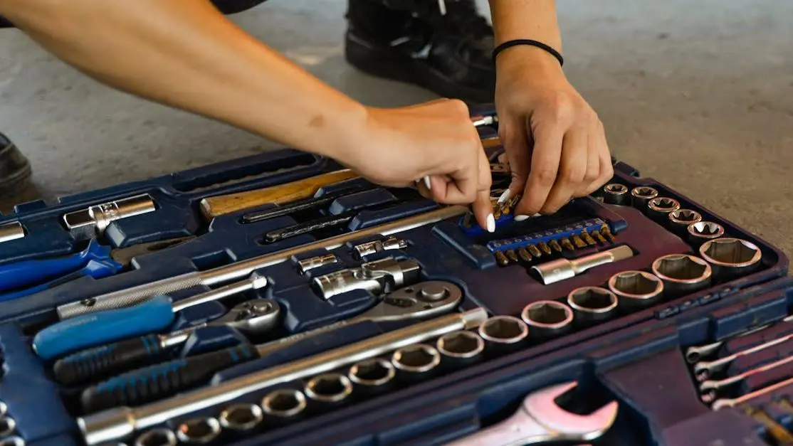 Mechanic selecting tool from toolbox with various aftermarket parts auto parts for vehicle repair