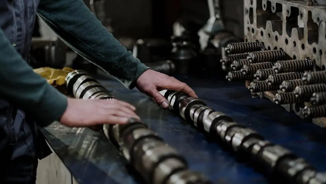 Mechanic handling camshafts and cylinder head with JEGS racing parts in automotive workshop